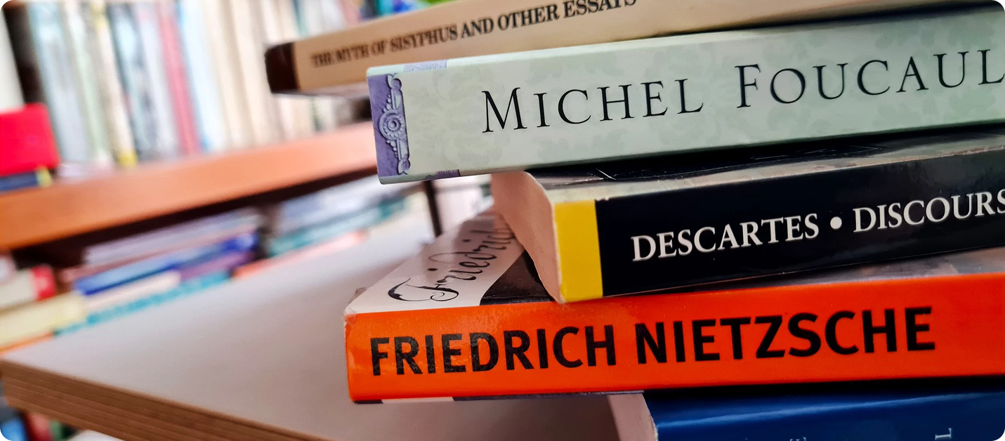 Close-up of book spines: Foucault, Descartes, and Nietzsche stacked together